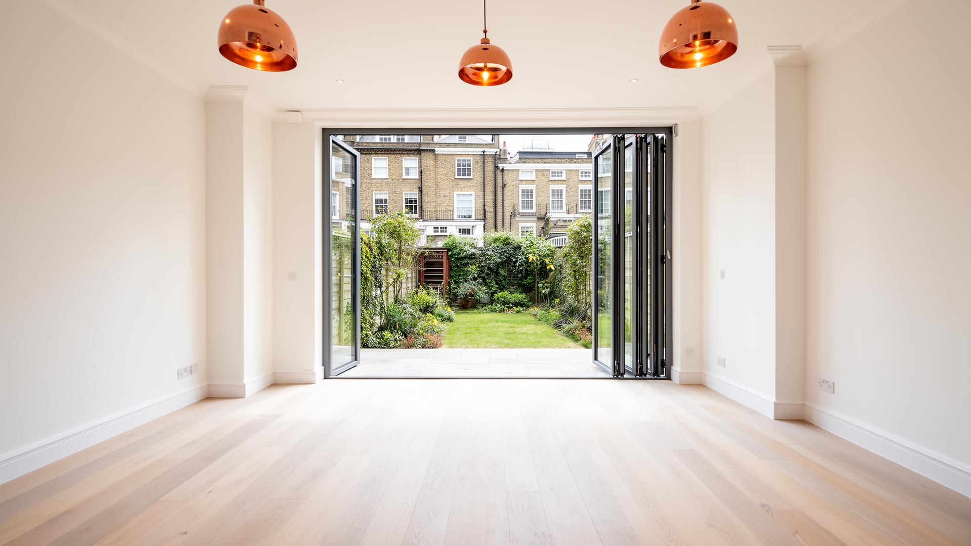 Renovated London townhouse interior with bifold doors opening onto a garden